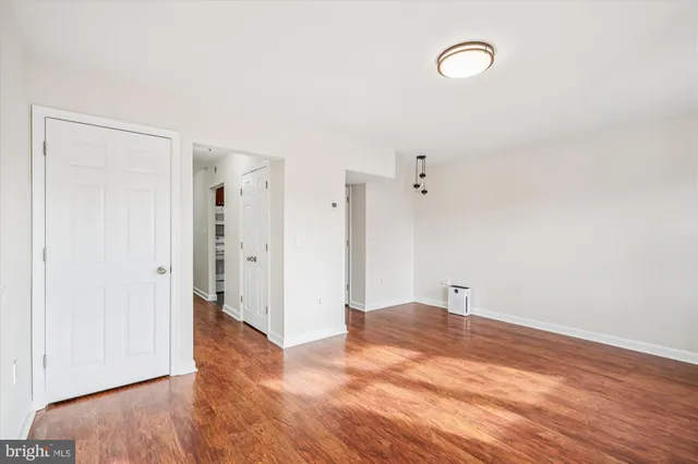 a view of empty room with wooden floor