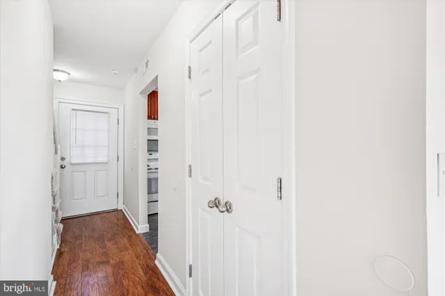 a view of a hallway with wooden floor and entryway