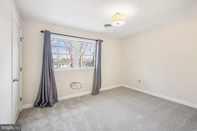 an empty room with a window and mirror