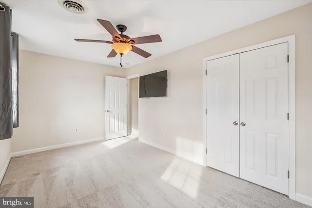 a view of empty room with ceiling fan