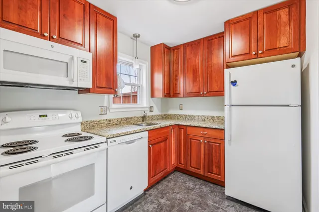 a kitchen with stainless steel appliances granite countertop a refrigerator sink stove and cabinets