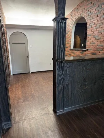 a view of a livingroom with entryway and wooden floor