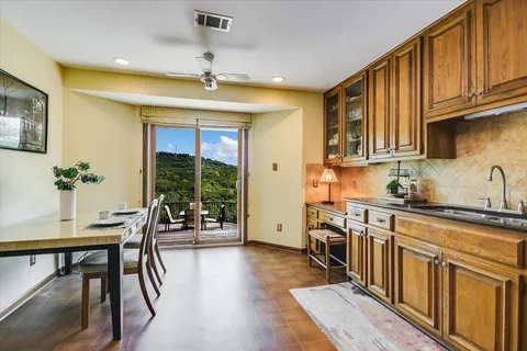 a kitchen with stainless steel appliances granite countertop a stove a sink dishwasher and a refrigerator with wooden floor