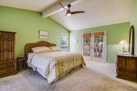 a spacious bedroom with a bed and a chandelier
