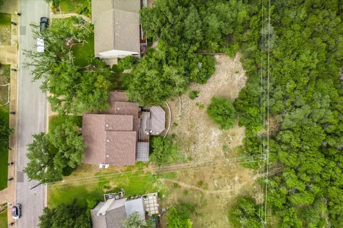 an aerial view of a houses with a lush green hillside