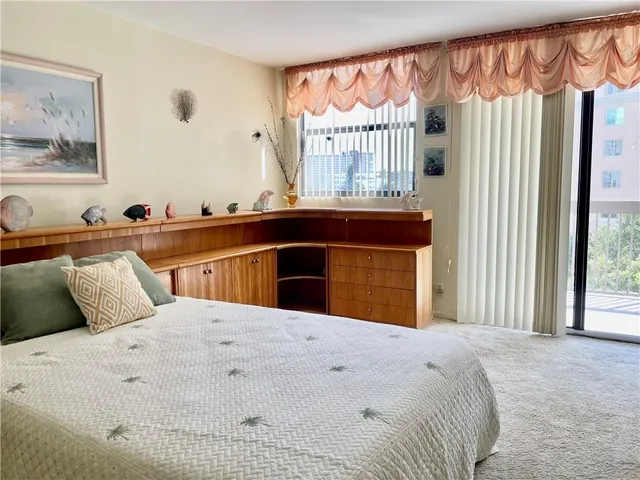 a bedroom with a bed and a large window