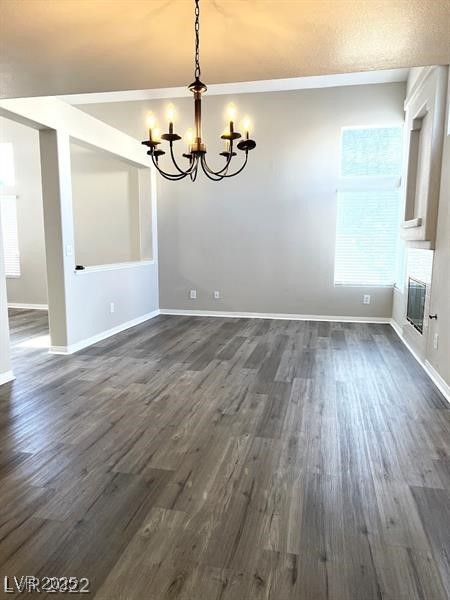6532 Moon Roses Court Las Vegas, NV 89108 - Photo 2 of 8 Unfurnished dining area featuring baseboards, dark wood-style flooring, and a notable chandelier