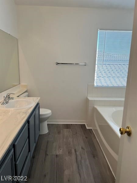 6532 Moon Roses Court Las Vegas, NV 89108 - Photo 6 of 8 Full bathroom with vanity, toilet, baseboards, a garden tub, and wood finished floors