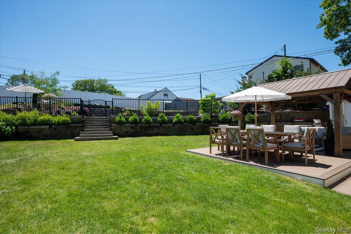 10 Rutgers Road Farmingville, NY 11738 - Photo 21 of 27 a view of a patio with dining table and chairs under an umbrella