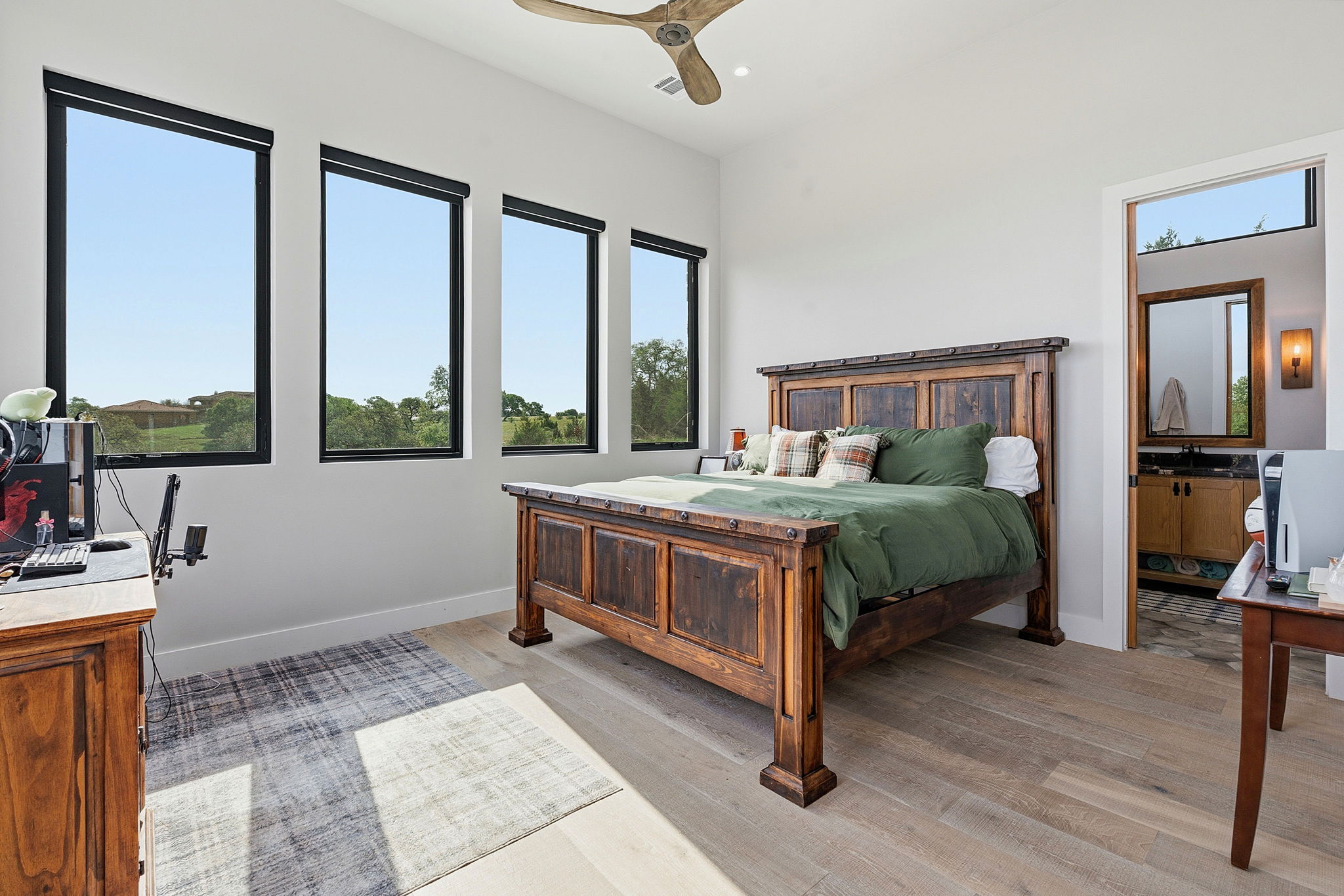 194 Placid Way Spring Branch, TX 78070 - Photo 16 of 37 Bedroom featuring wood-finish flooring, a ceiling fan, and multiple tall windows with black frames
