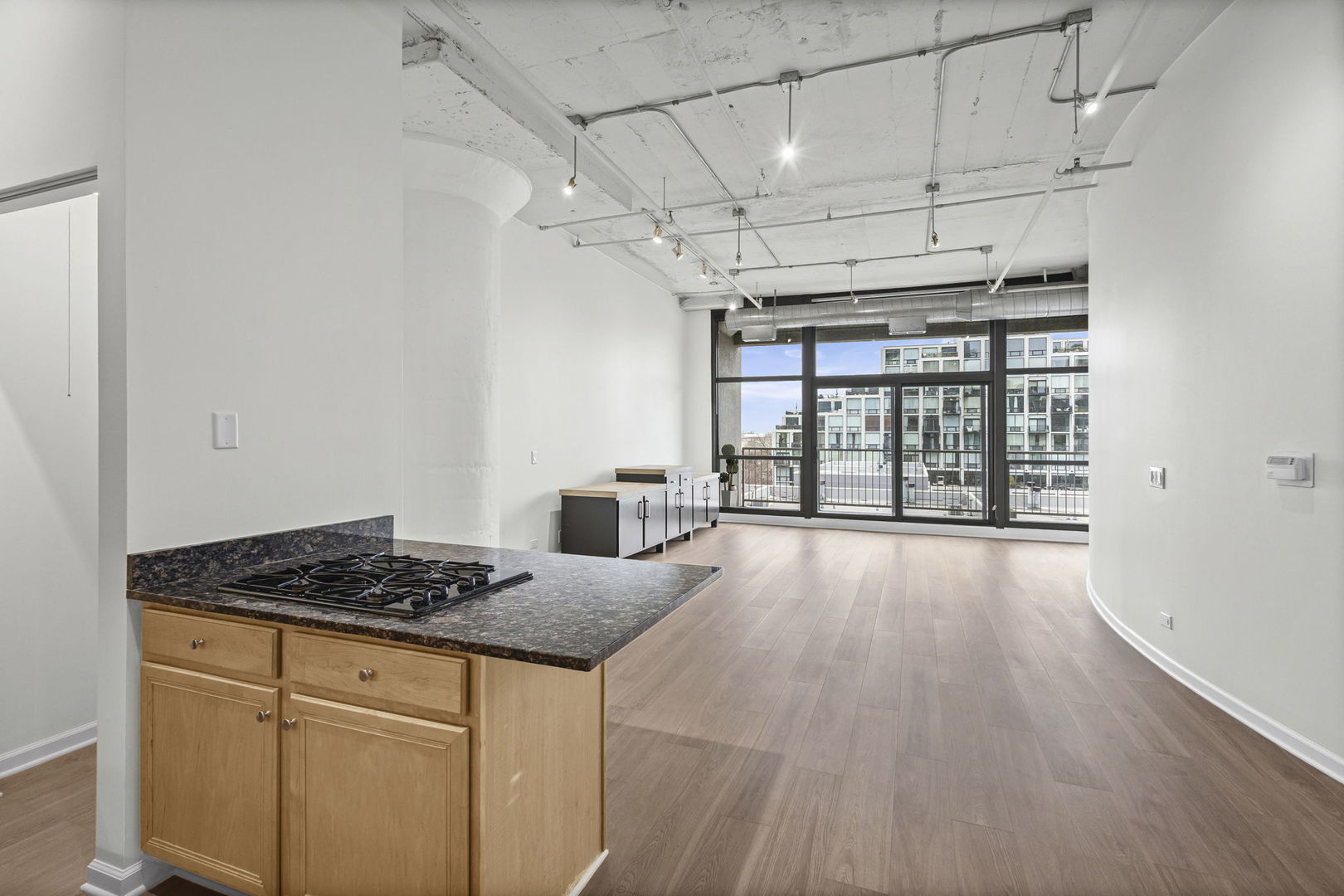 1530 South State Street, Unit 431 Chicago, IL 60605 - Photo 5 of 15 a kitchen with granite countertop a stove a sink and white cabinets with wooden floor