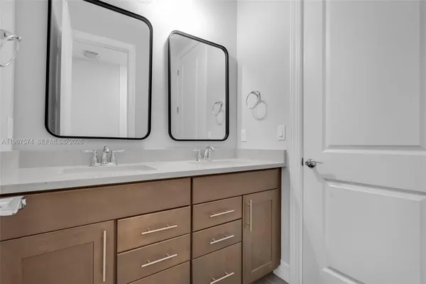 a bathroom with double vanity sinks and a mirror