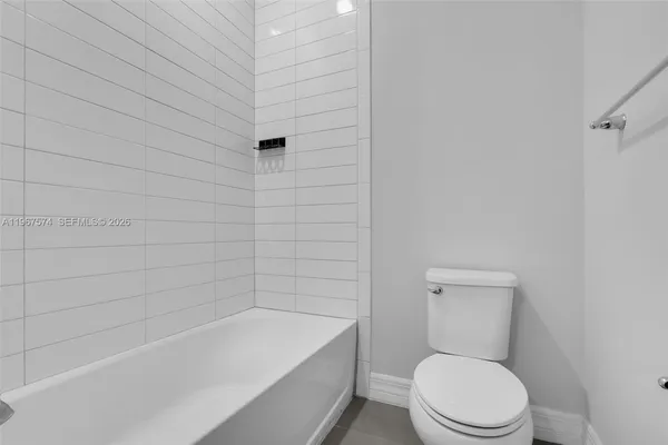a white toilet sitting next to a bath tub