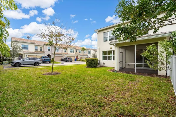 a view of a house with a big yard and large trees