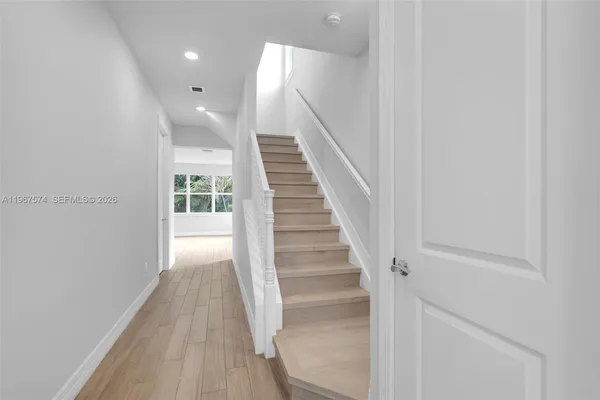 a view of entryway and hall with wooden floor