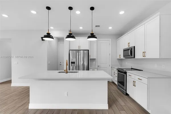 a kitchen with stainless steel appliances kitchen island a large island in the center