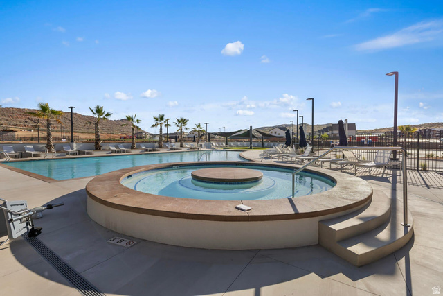 2133 Wolverine Way, Unit 2440 Washington, UT 84780 - Photo 28 of 39 Resort-style pool area featuring a large swimming pool, circular spa with integrated steps, and surrounding concrete decking