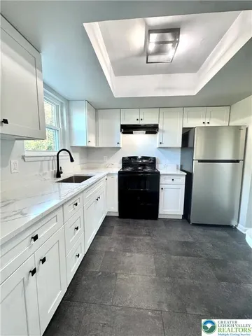 a kitchen with granite countertop stainless steel appliances a refrigerator a sink a stove a dining table and chairs