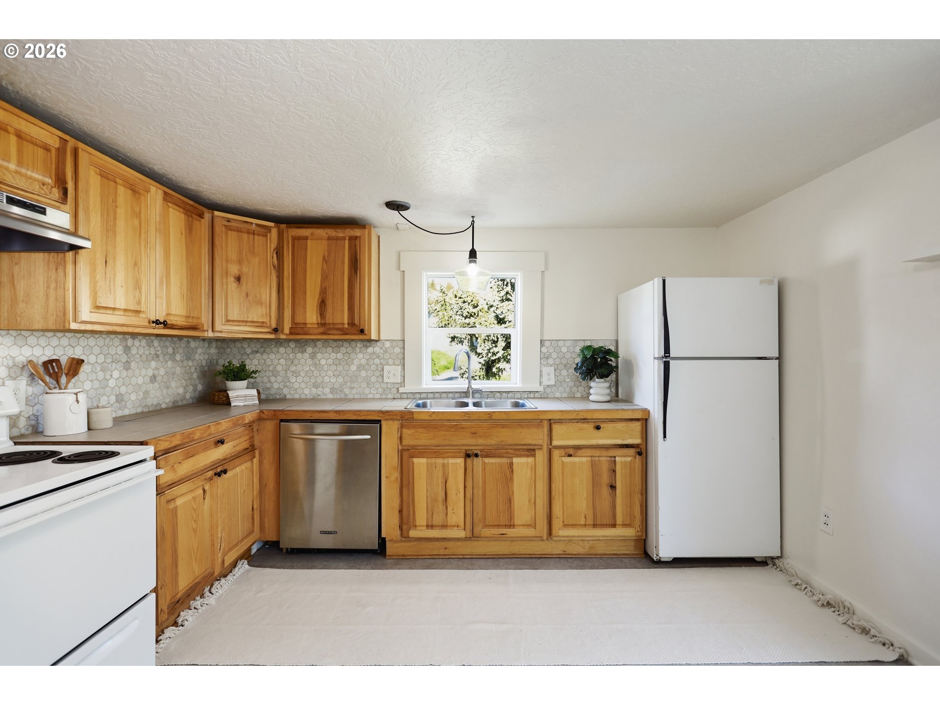 180 Northwest Spring Street White Salmon, WA 98672 - Photo 15 of 44 a large kitchen with stainless steel appliances granite countertop a refrigerator a stove a sink and a white cabinets
