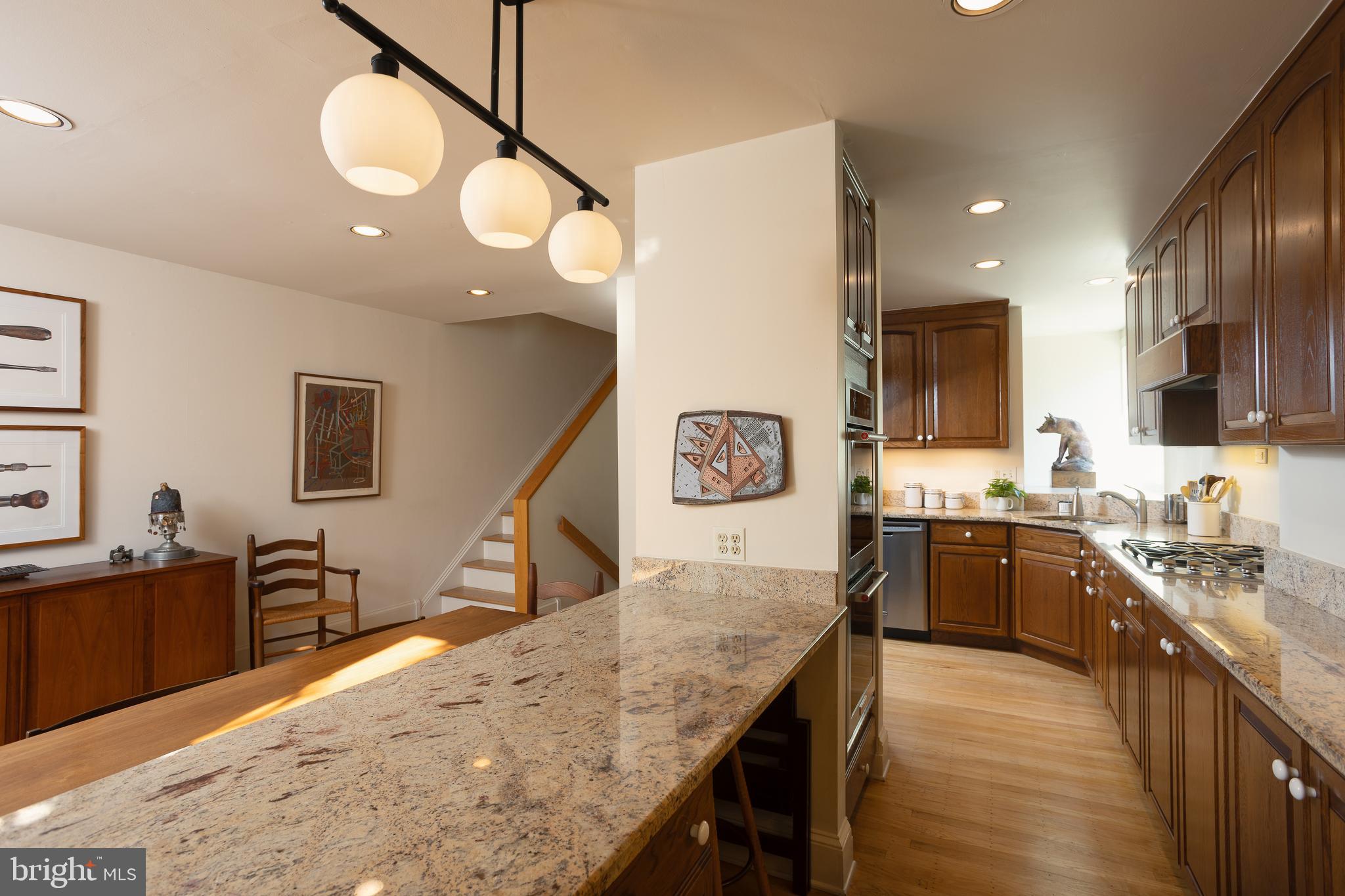 430 South 5th Street Philadelphia, PA 19147 - Photo 30 of 32 a kitchen with stainless steel appliances granite countertop sink stove refrigerator dining table and chairs