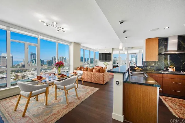 a living room with furniture kitchen view and a large window