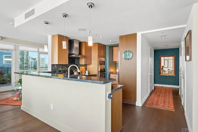 a view of a kitchen with kitchen island stainless steel appliances wooden floor and window