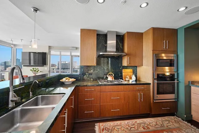 a kitchen filled counter top space a sink cabinets and stainless steel appliances