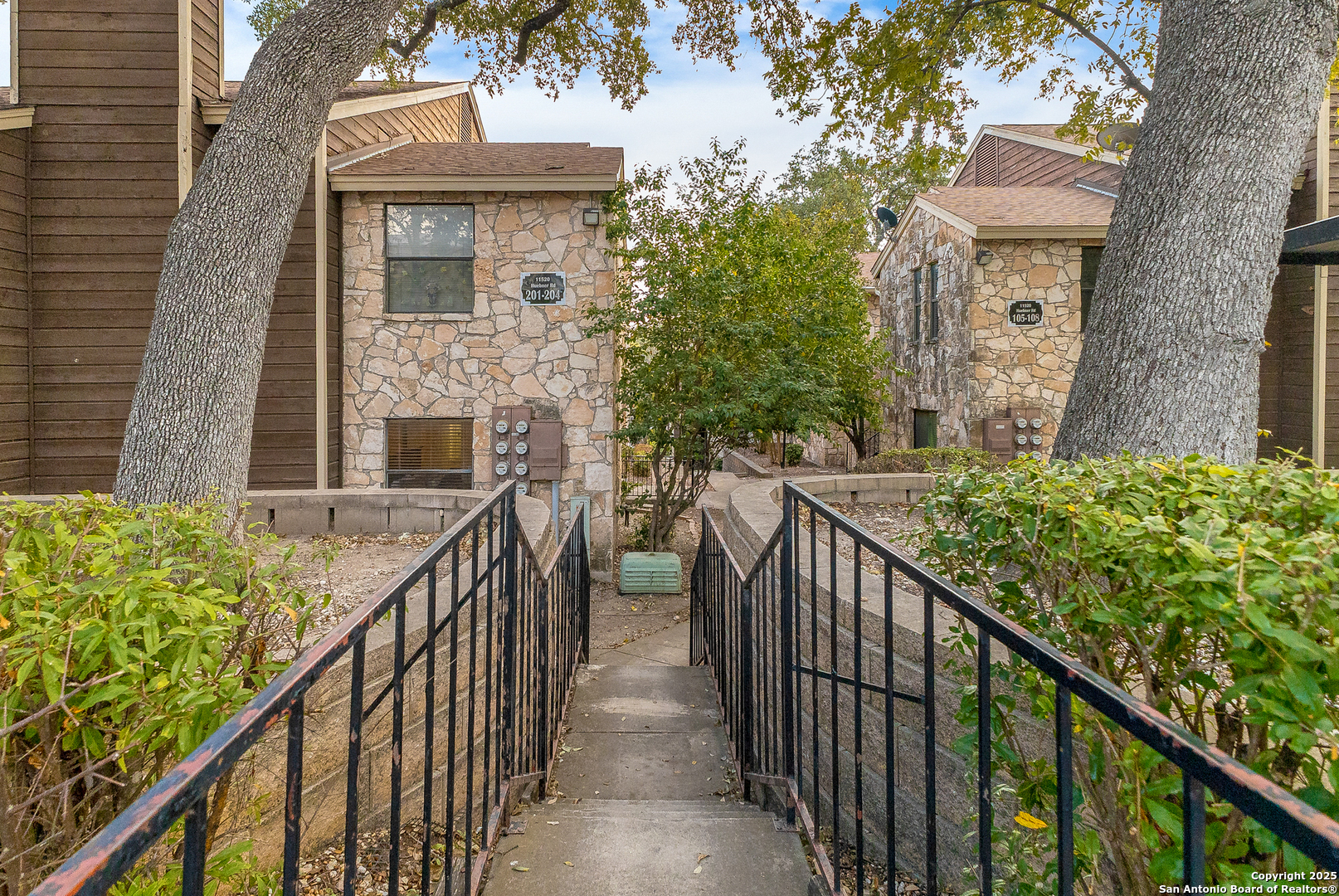 a view of a brick house with wooden fence