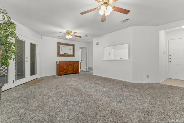 a view of empty room with ceiling fan