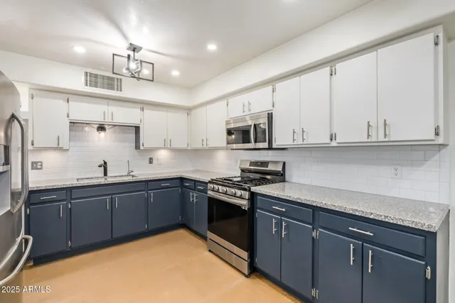 a kitchen with stainless steel appliances granite countertop a sink stove and microwave