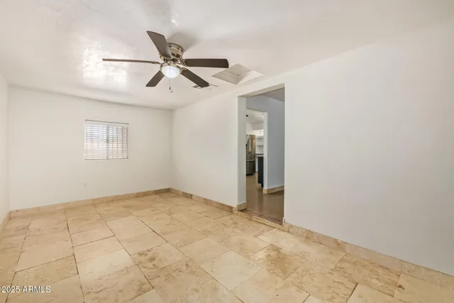 an empty room with windows and fan