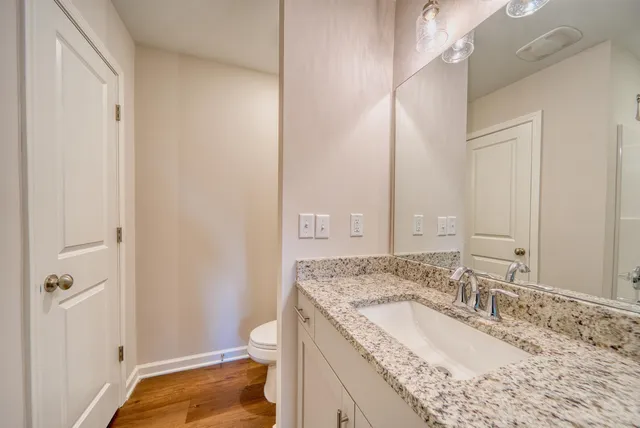 a bathroom with a granite countertop tub sink and mirror