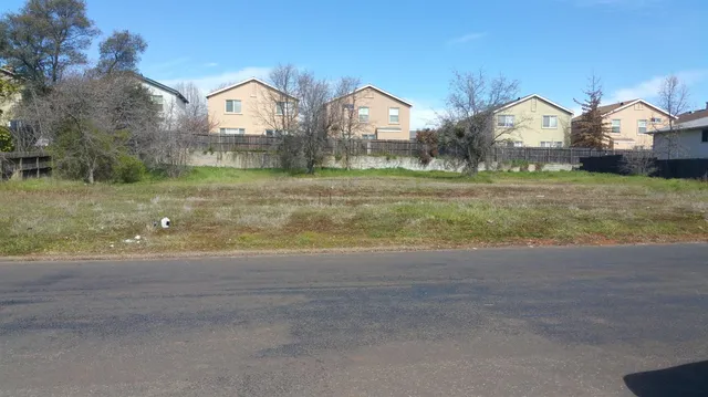 a view of a large house with a big yard and large trees