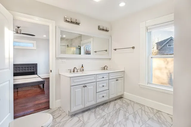 a spacious bathroom with a granite countertop sink and a mirror