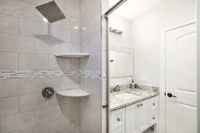 a bathroom with a granite countertop sink a toilet and shower