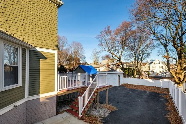a view of backyard of house with wooden fence