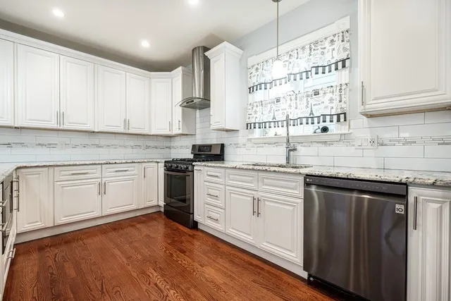 a kitchen with granite countertop white cabinets and white appliances