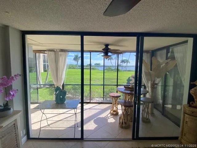 a view of a room with wooden floor and floor to ceiling windows