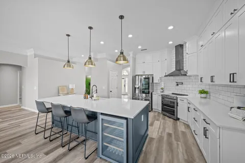 a kitchen with a stove a sink a window and cabinets