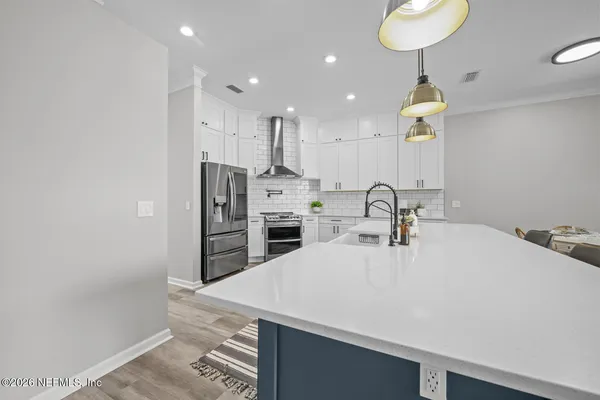 a large kitchen with kitchen island a stove a sink a chimney and wooden floor