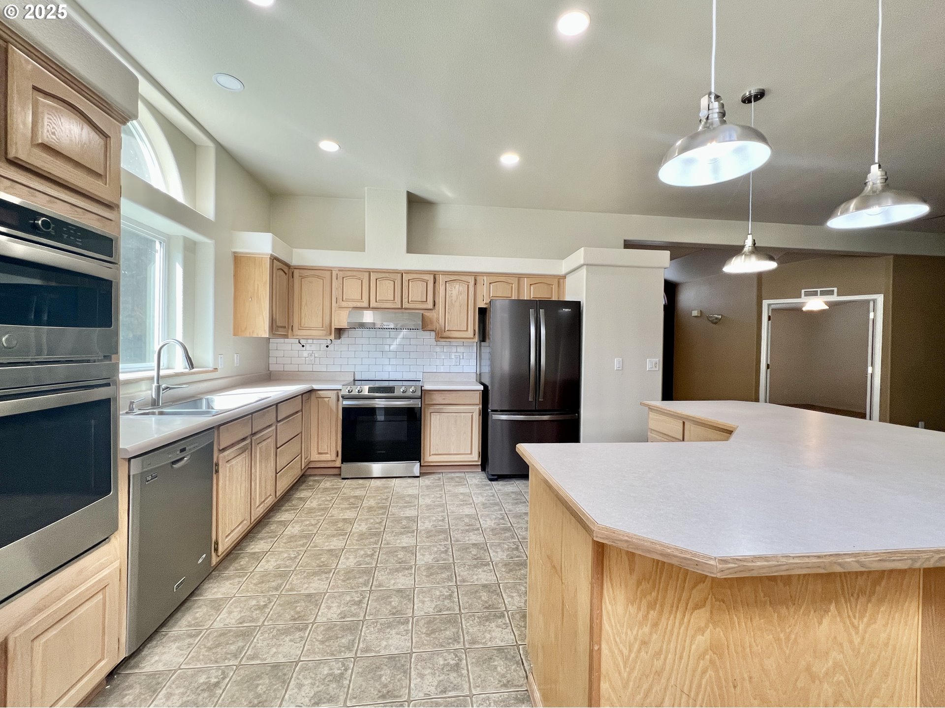 76707 Highway 207 Echo, OR 97826 - Photo 14 of 25 a large kitchen with stainless steel appliances kitchen island granite countertop a sink refrigerator and cabinets