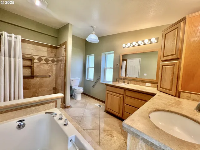 a spacious bathroom with a granite countertop tub sink a mirror a vanity and shower