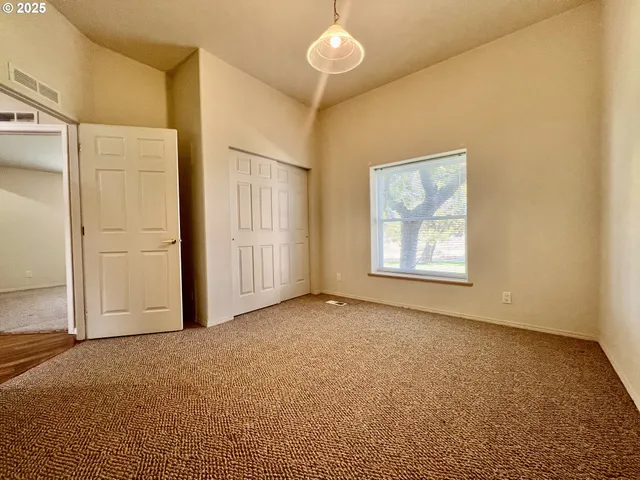 an empty room with windows and cabinet