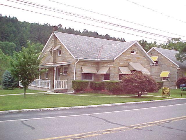 a view of a big house with a big yard and large trees