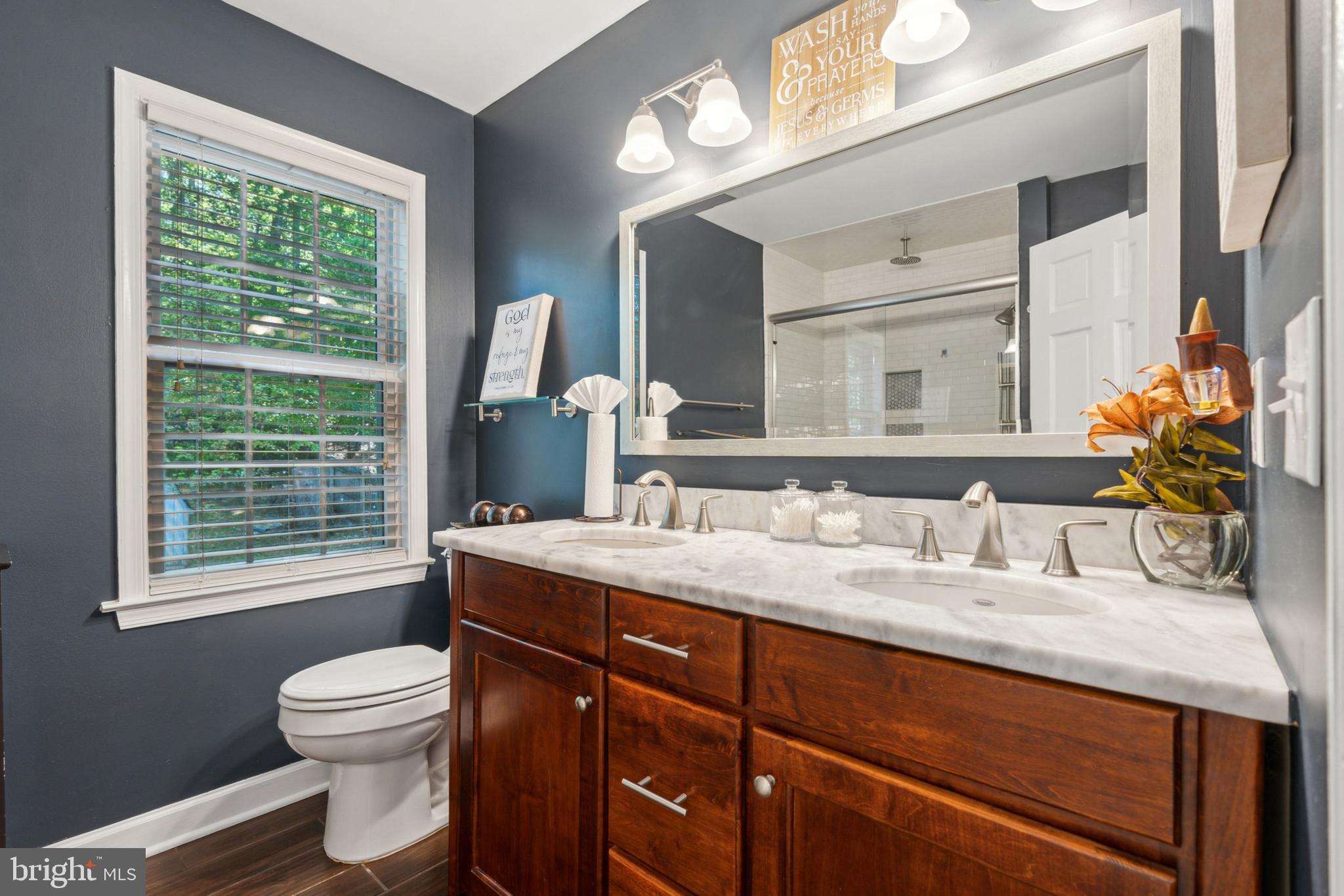 18600 Cabin Road Triangle, VA 22172 - Photo 28 of 39 a bathroom with a granite countertop sink toilet a large mirror and a window