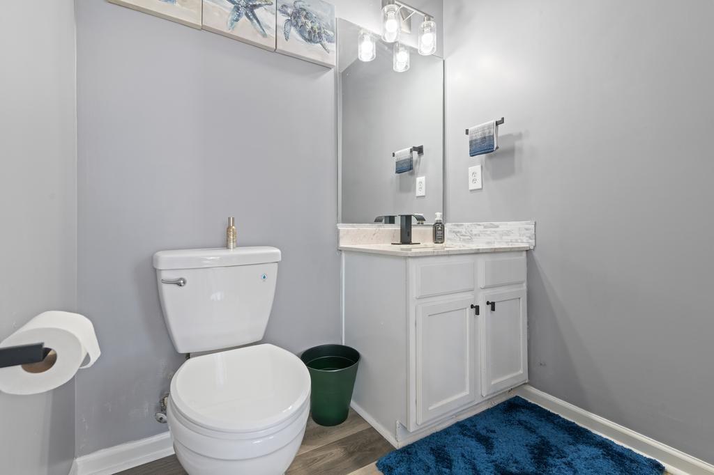 5914 Waggoner Court Rex, GA 30273 - Photo 14 of 23 a bathroom with a toilet a sink and wooden floor