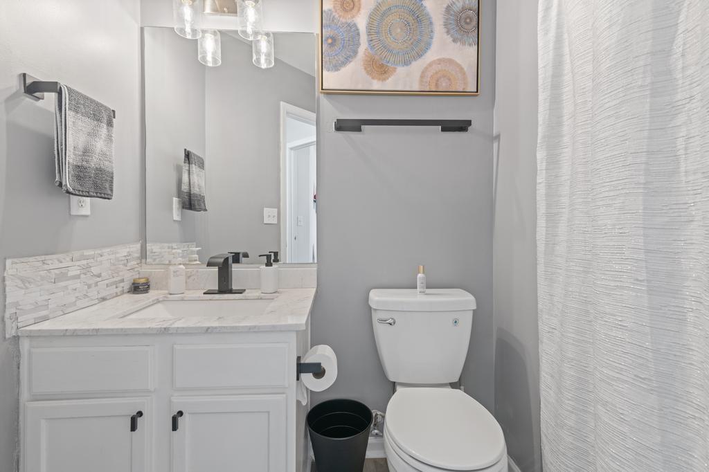 5914 Waggoner Court Rex, GA 30273 - Photo 21 of 23 a bathroom with a toilet sink vanity and mirror
