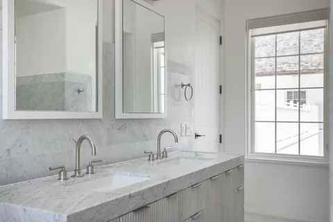 a spacious bathroom with a double vanity sink a mirror and a bathtub