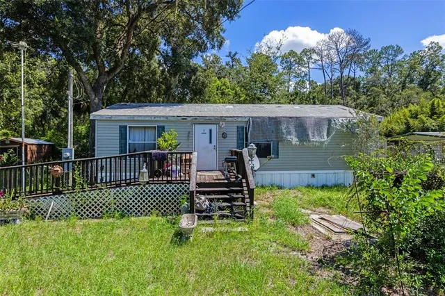 a view of a chair and table in the back yard of the house