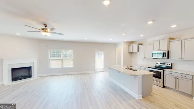 a view of kitchen with sink a microwave and cabinets